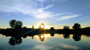 A calm lake with trees reflecting the sky.