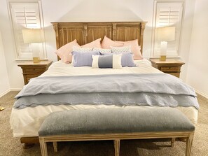 Classic bedroom with a large bed, nightstands, and a bench.