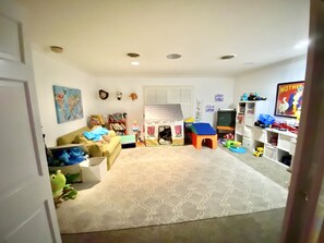 Cozy living space with a sofa, table, bookshelf, and play area.