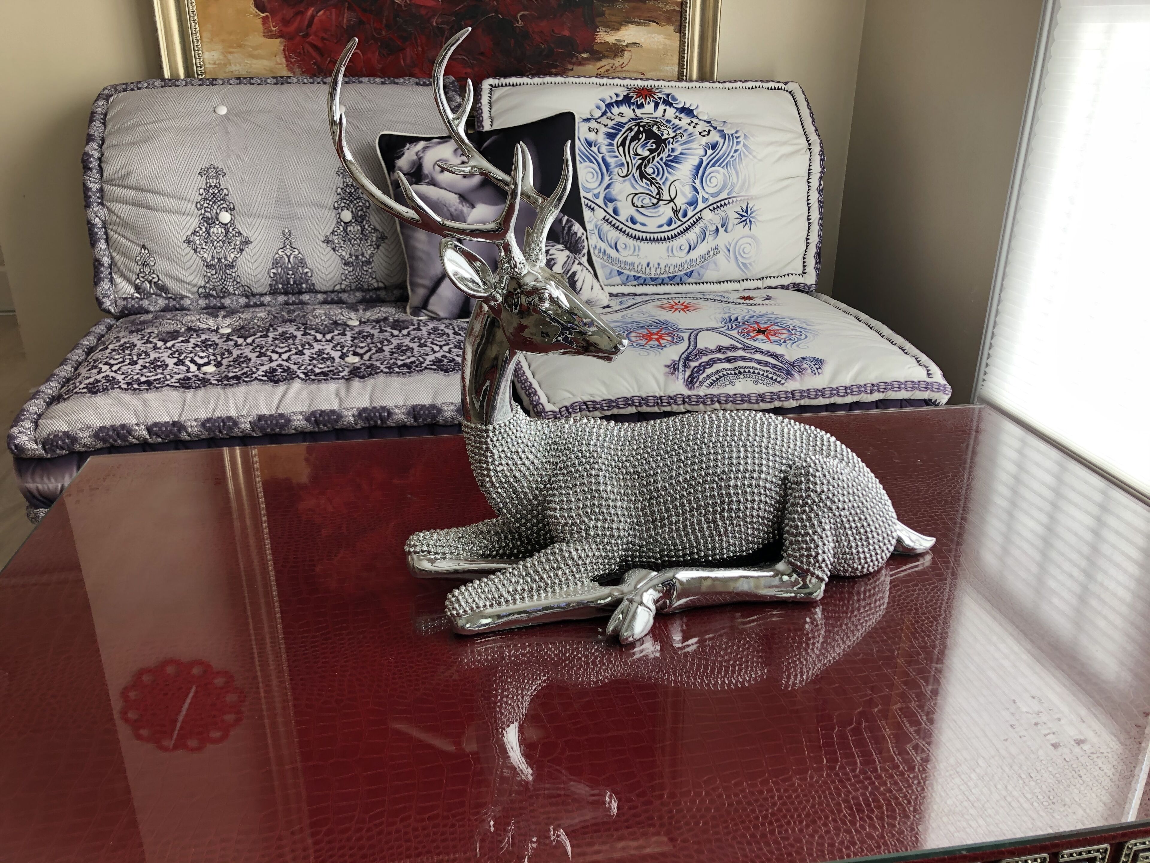 Un sofá con cojines estampados y un tapiz decorativo.
