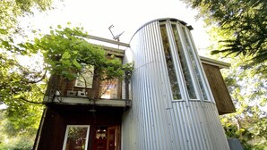 Un edificio pequeño de una sola planta con fachada de metal corrugado y puerta de madera.