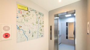 An elevator with a digital display and a wall-mounted map of Kyoto City. - M's Hotel Kyoto Station Taruya (Kyoto)