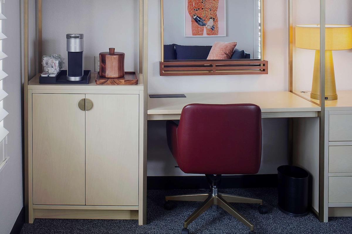 Un espace de travail moderne et compact, comprenant un bureau, une chaise et des éléments de rangement.