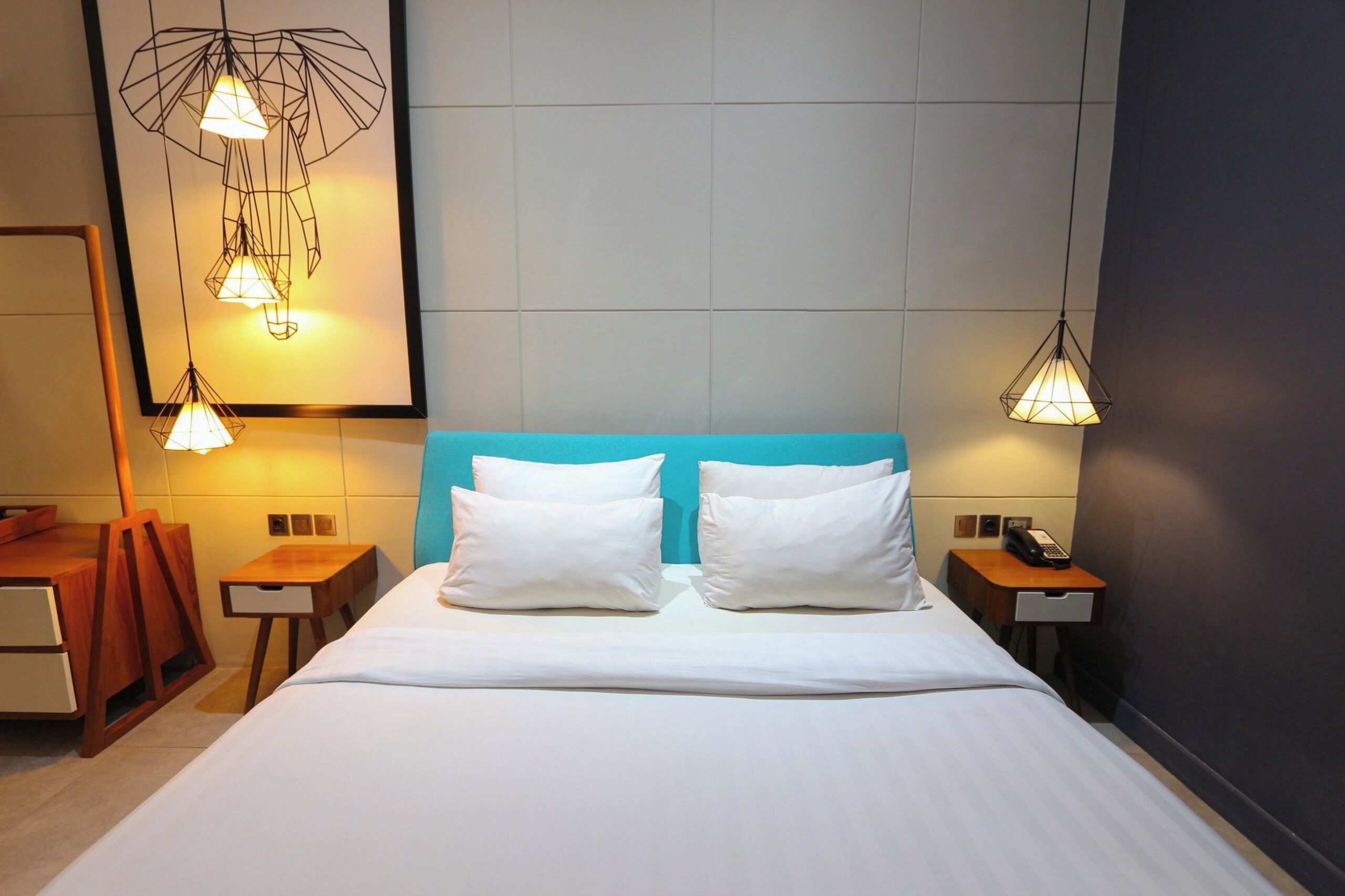 A hotel room with a bed, two bedside tables, a nightstand, a desk, and a chair.