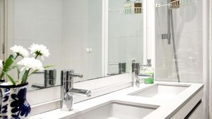 A modern bathroom with two sinks, a large mirror, and a shower. - Spacious, Central and Authentic Family Apartment (Donostia)