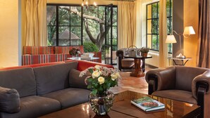 A modern living room with a sofa, armchairs, a coffee table with a vase of flowers, and large windows with curtains. - La Bastide de Barbeiranne Maxi 14 persons (Pignans)