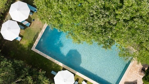 An aerial view of a rectangular swimming pool surrounded by a brick deck, with two white umbrellas and lounge chairs. - La Bastide de Barbeiranne Maxi 14 persons (Pignans)