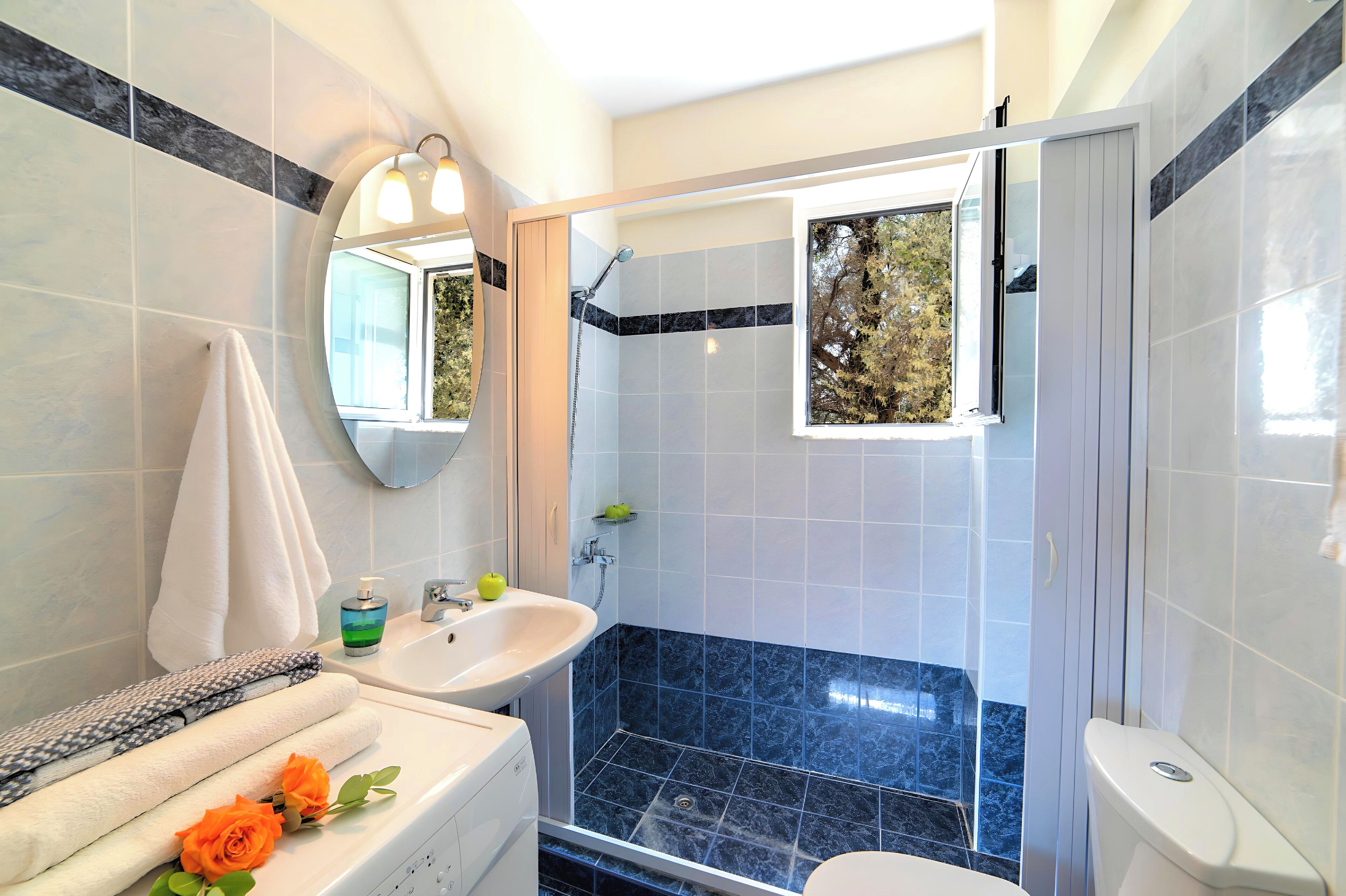 Et moderne badeværelse med bruser, vask og toilet.