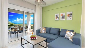 Uma sala de estar moderna com um sofá, uma mesa de centro com frutas e uma varanda com móveis para área externa.