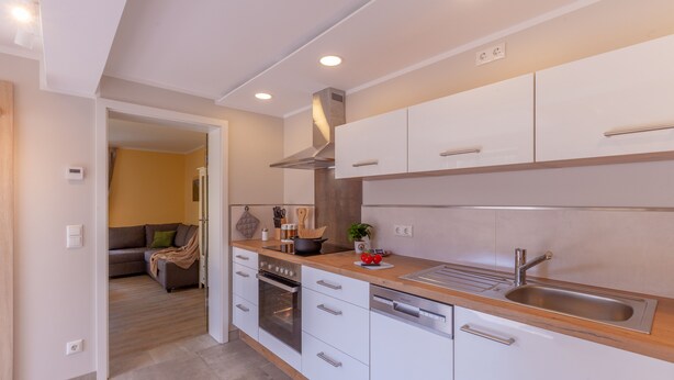 A modern kitchen with white cabinets, stainless steel appliances, and a wooden countertop. - Vacation in Saxon Switzerland (Pirna OT. Graupa)