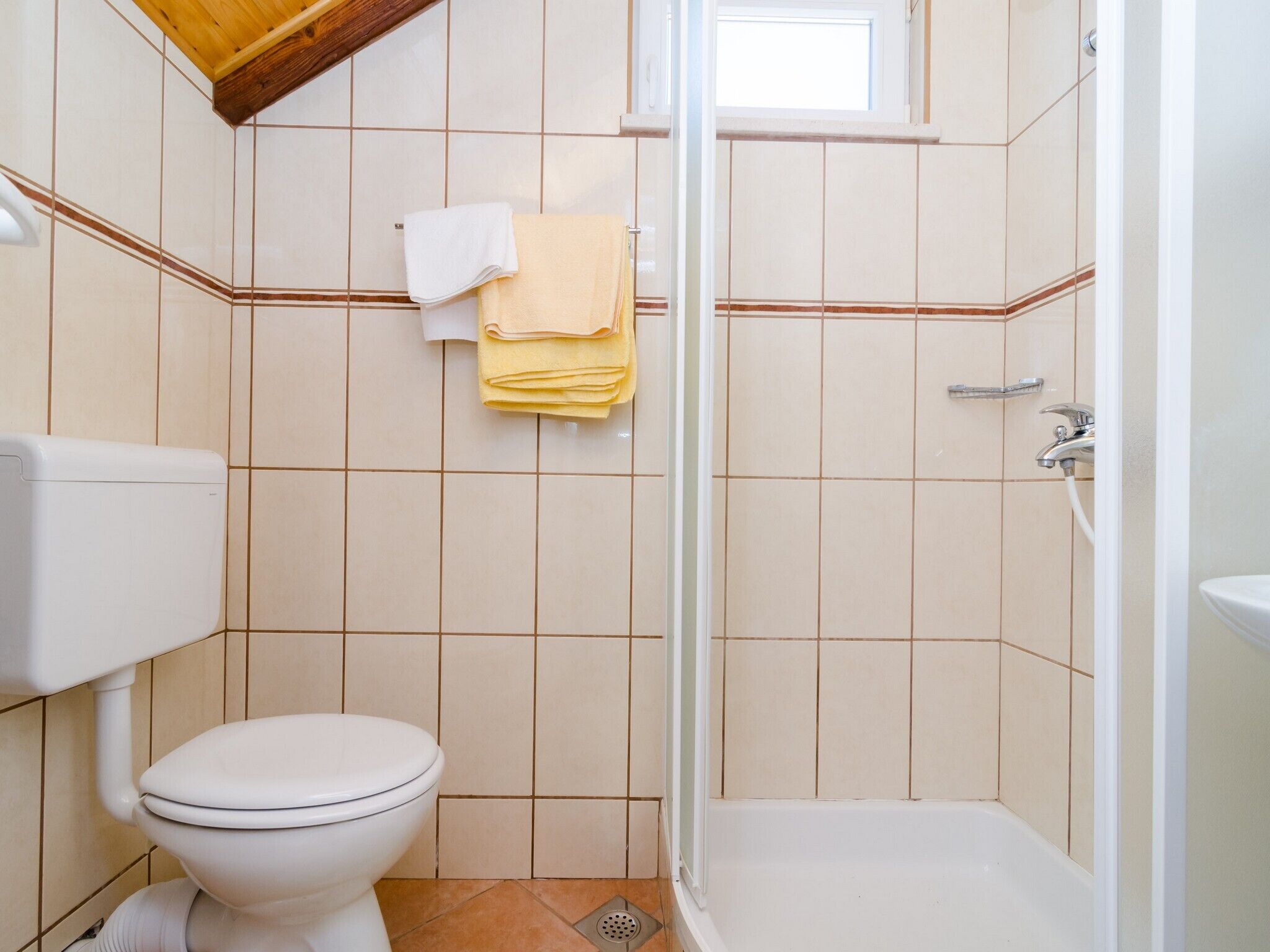 A bathroom with a toilet, a shower, and a sink.