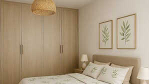 A bedroom with a bed, nightstands, a wardrobe, and two framed botanical prints on the wall.