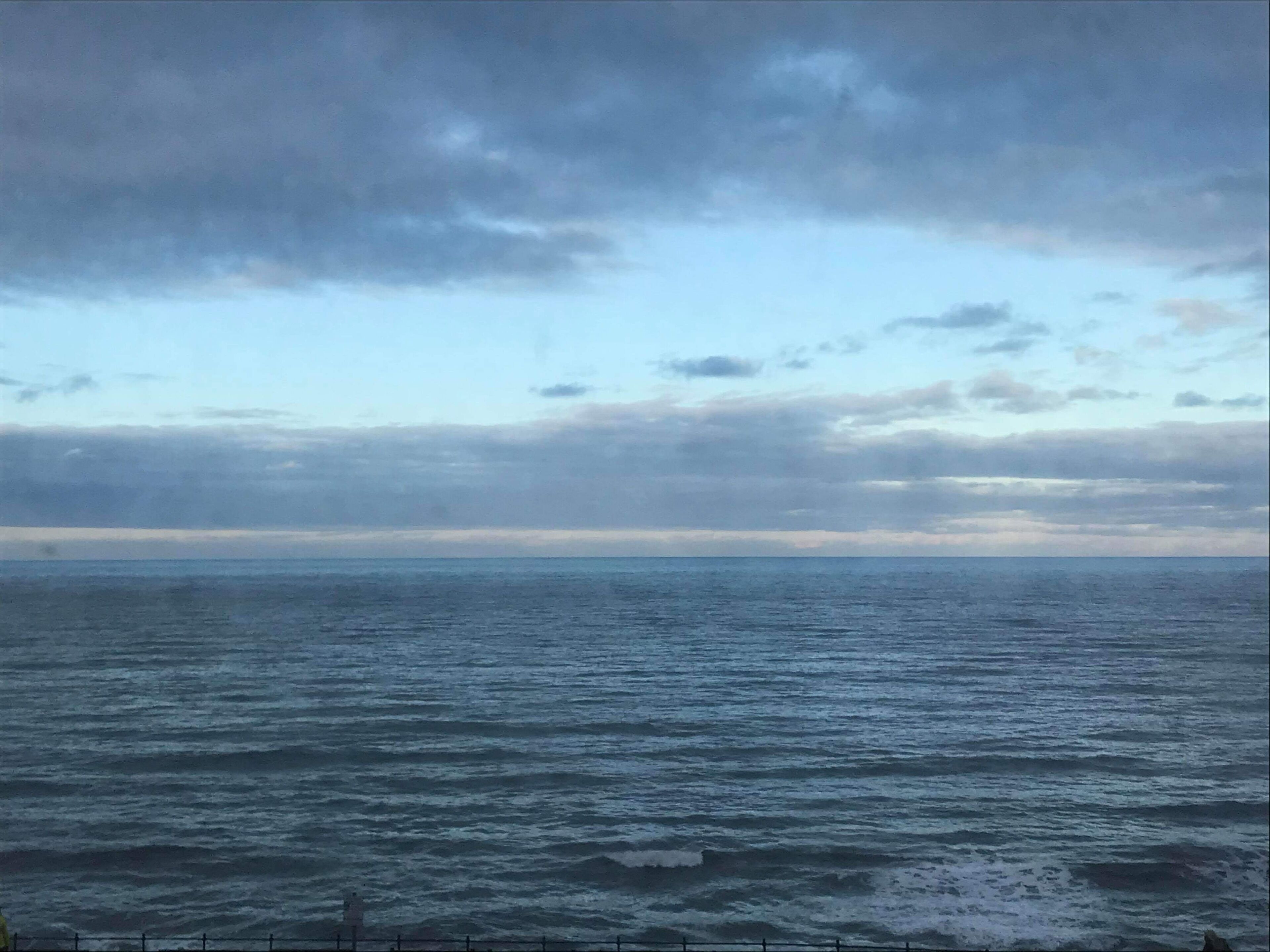 Une vue sur l’océan, avec un ciel nuageux.