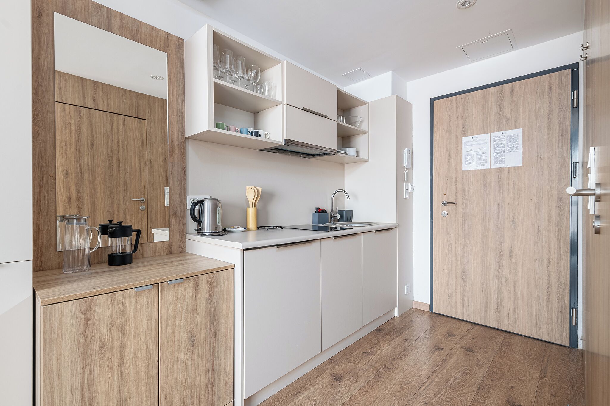 Una cocina moderna con armarios de madera, encimera blanca y estufa integrada.
