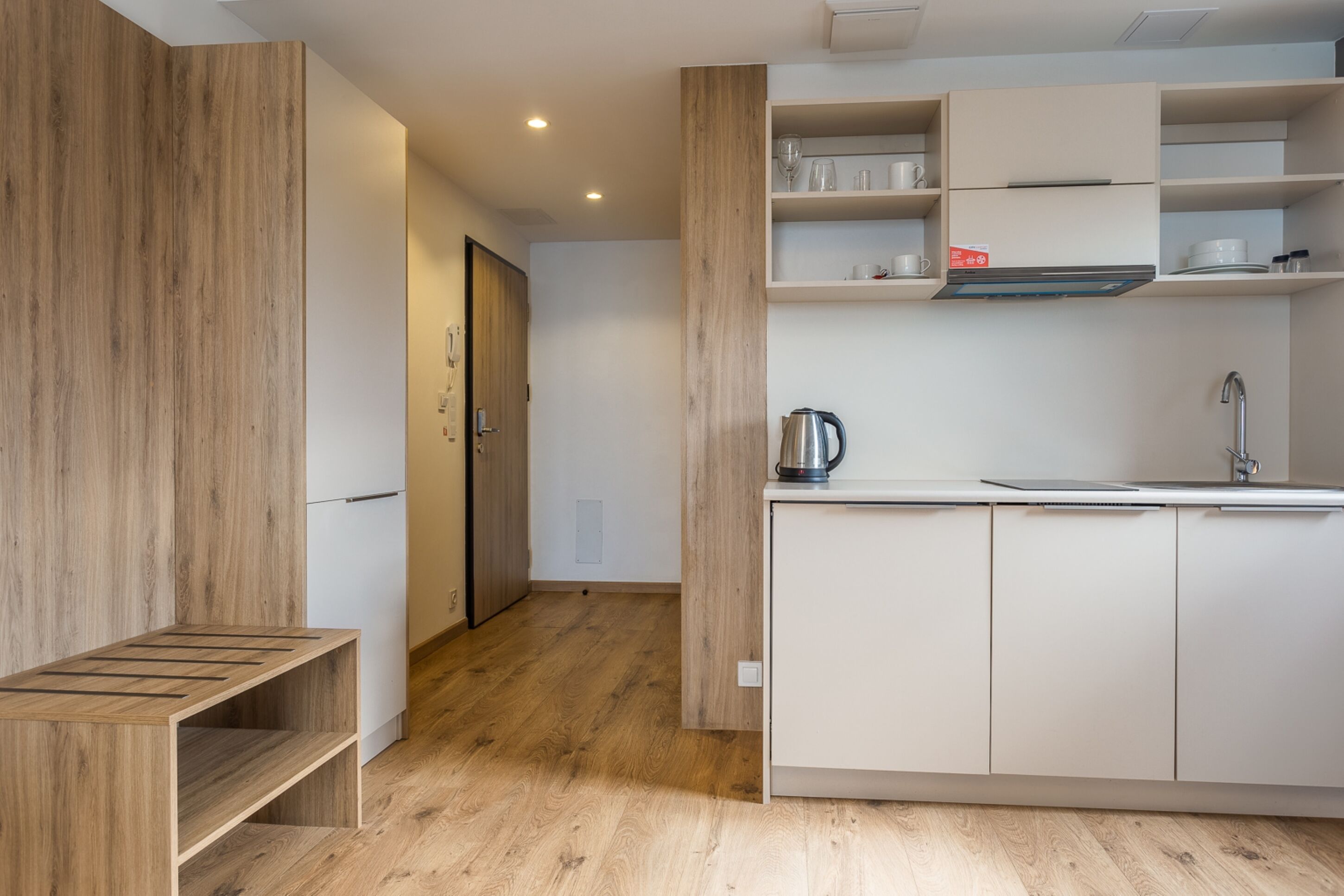 Una cucina moderna con mobili in legno, forno incassato e lavello in acciaio inox.