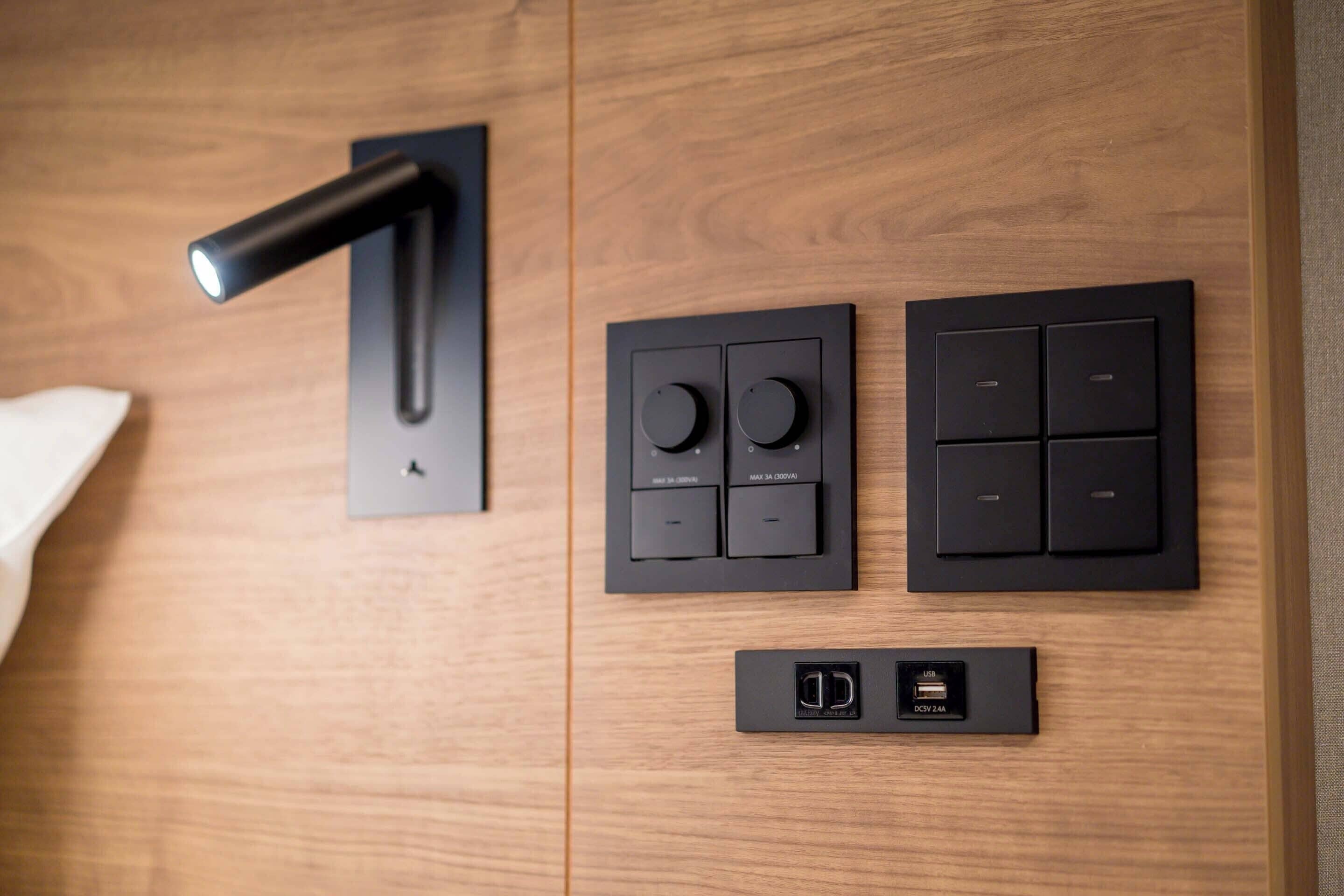 Een modern bedieningspaneel met een deurklink, twee ronde knoppen, vier vierkante knoppen en een USB-laadpoort.