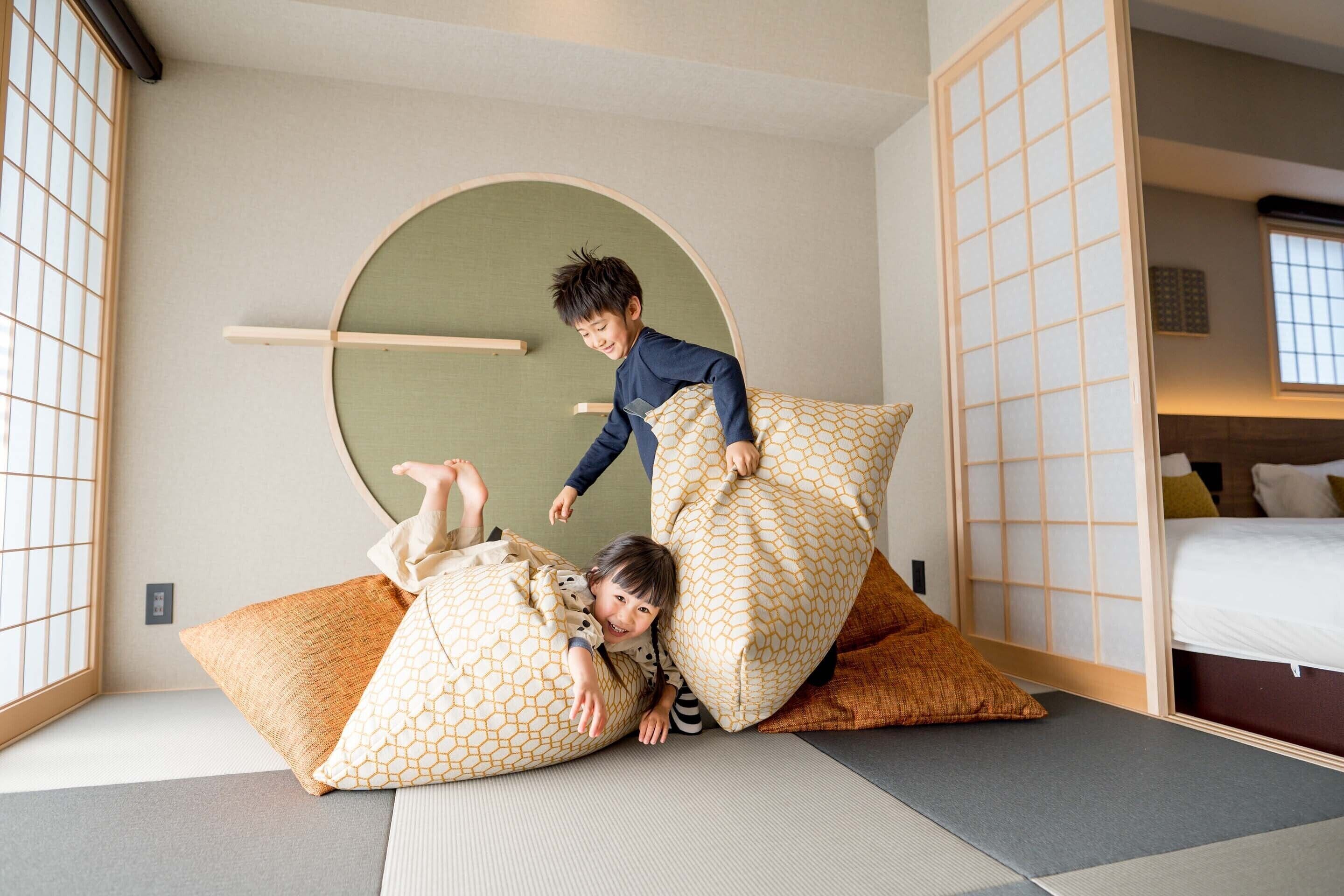 Ein Zimmer mit Tatami-Böden, einem niedrigen Holzbett und einer traditionellen Schiebetür.