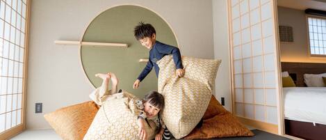 A room with tatami flooring, a low wooden bed, and a traditional sliding door.