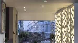Un interior moderno con pared de piedra, plantas en macetas y un diseño decorativo en la pared.