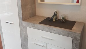 Un baño con un mueble blanco, un lavabo y un espejo.