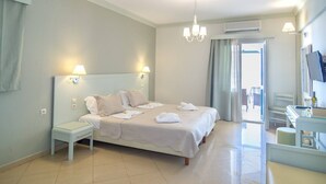 A hotel room with a large bed, bedside tables, a desk, and a TV. - Elena Apartments (Kalymnos)