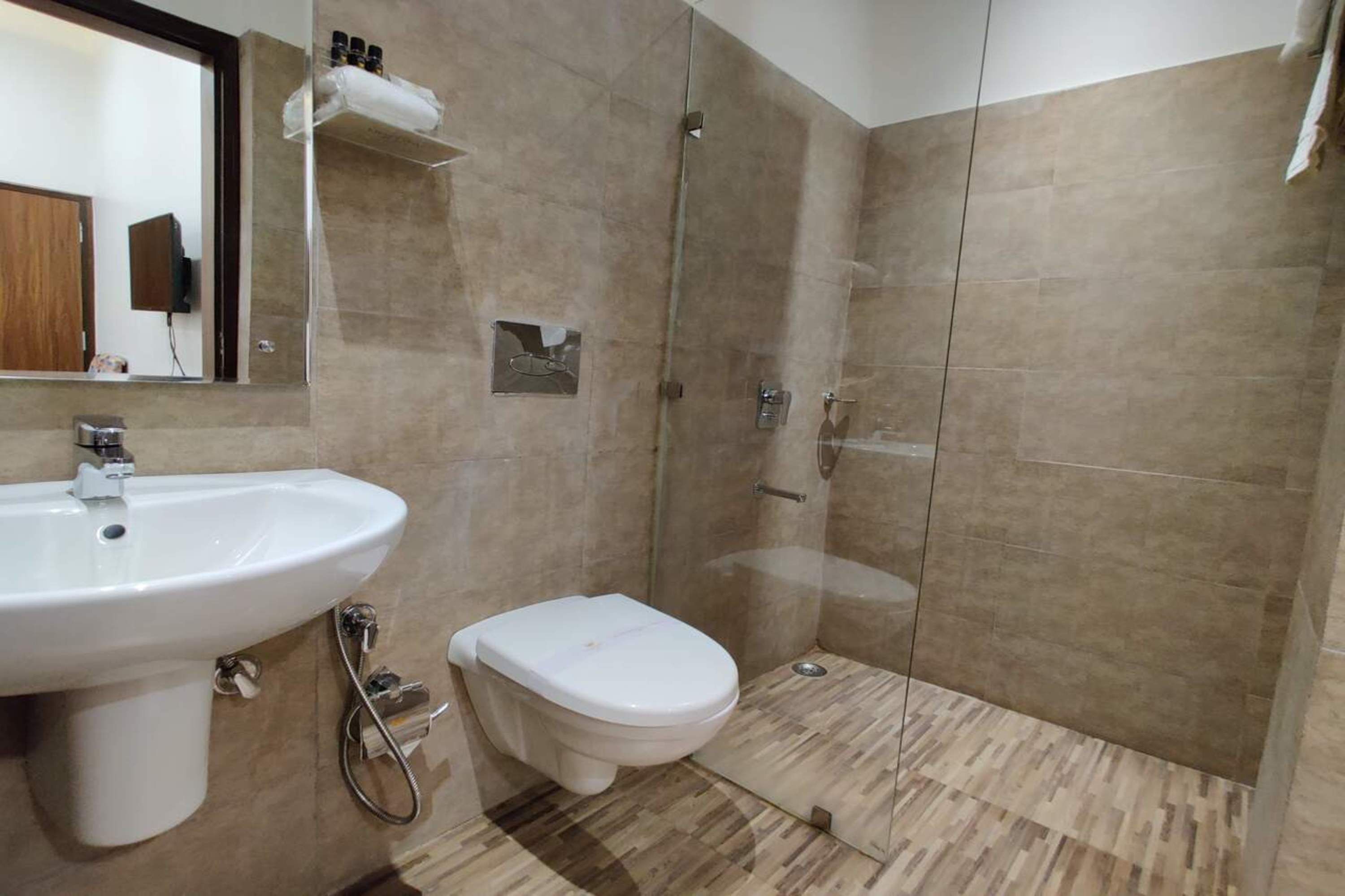 A bathroom with a sink, toilet, and glass-enclosed shower.