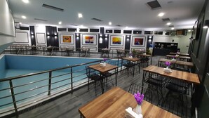 A modern indoor pool area with multiple seating arrangements and artwork on the walls. - Asiwa Otel (Eskisehir)