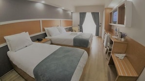 A hotel room with two beds, a desk, a TV, and a window with curtains. - Asiwa Otel (Eskisehir)