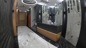 A hotel reception area with a marble floor, a reception desk, and a modern ceiling design. - Asiwa Otel (Eskisehir)