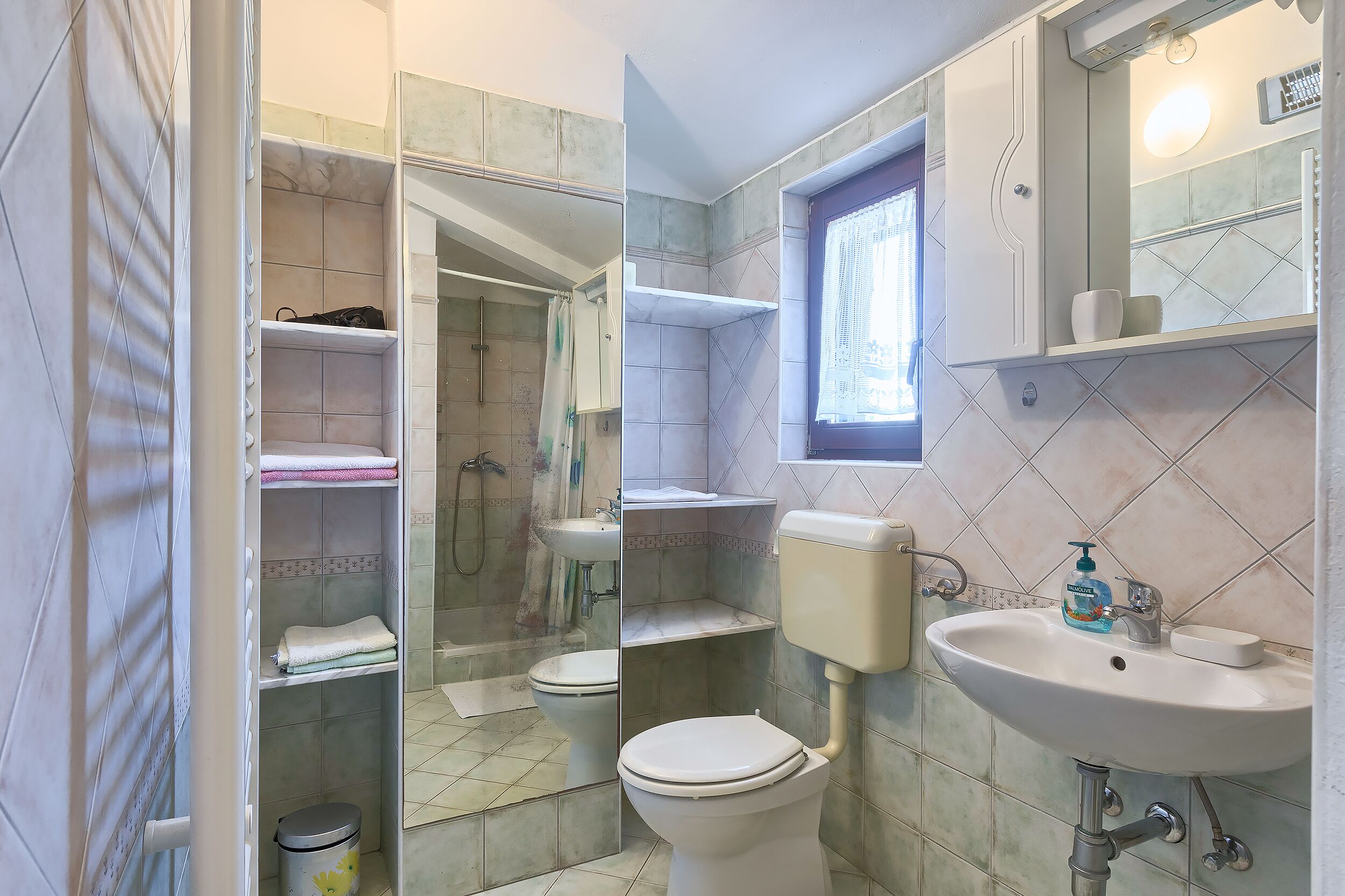 A bathroom with a toilet, sink, and shower area.