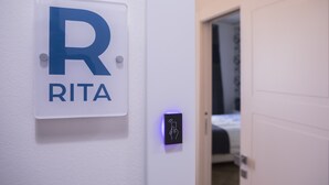 Opastekyltti, jossa on suuri kirjain »R» ja sana »RITA», ja joka osoittaa huoneen numeron tai huonetyypin.