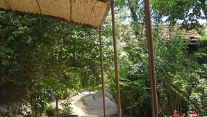 Un espacio al aire libre cubierto con un muro de piedra, un sendero y vegetación.