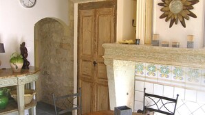 Un comedor con una mesa de madera, sillas, un jarrón decorativo y un reloj de pared.