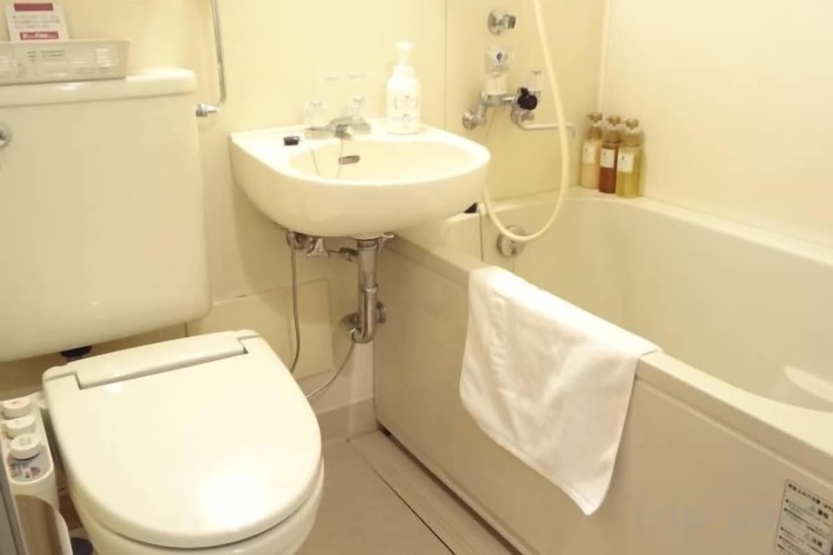A bathroom with a toilet, sink, and bathtub.