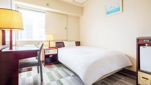 A hotel room with a bed, a desk with a lamp, a chair, a bedside table with a phone, and a picture on the wall. - Hotel Paco Obihiro Chuo (Obihiro)