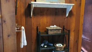 A wooden room with a shelf holding towels and a basket. - The Historic Northern Hotel (Coolin)