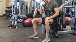 A gym with exercise equipment, a seated man wiping sweat, and a woman lying on an exercise ball. - Hyatt Centric Rittenhouse Square Philadelphia (Philadelphia)