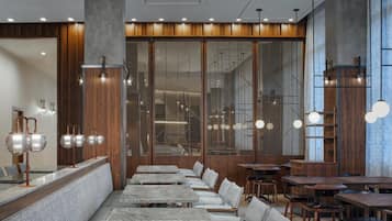 A modern restaurant interior with marble counters, wooden paneling, and multiple seating arrangements.