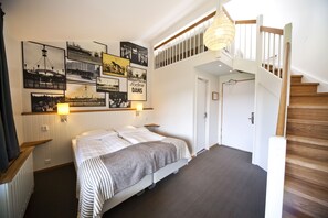 A bedroom with a bed, a staircase, and wall art. - Lisebergsbyn Bed & Breakfast (Gothenburg)