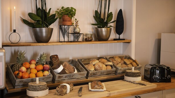 Un plan de travail de cuisine avec divers aliments, un grille-pain et des plantes décoratives.