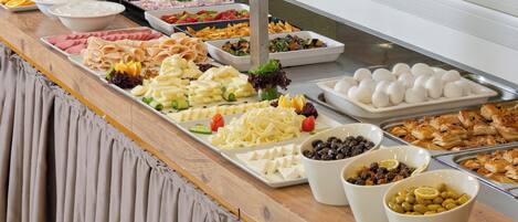 A buffet with various food items including meats, cheeses, and salads.