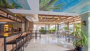 A spacious bar area with high stools and a counter, large windows, and a ceiling mural. - Citrus Park Hotel (Konyaalti)