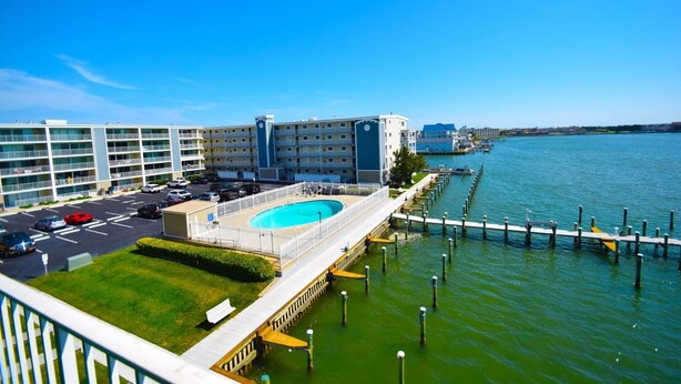 A hotel with a swimming pool, a dock, and a view of the water. - Thunder Island 80b 2 Bedroom Condo by RedAwning (Ocean City)