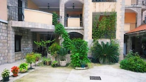 Pátio com plantas em vasos e uma parede de pedra.