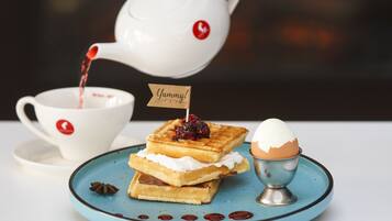 Um prato com waffles, uma pequena bandeira e uma xícara de chá.