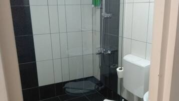Ein kleines Badezimmer mit Toilette, Dusche und Waschbecken.