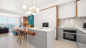 A modern kitchen with a central island, built-in appliances, and a view to the outside. - Stunning View Apartment - Adults Only (Nazaré)