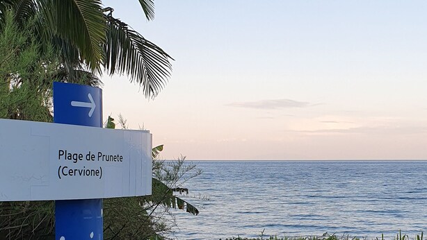 A signpost with 'Plage de Prunete (Cervione)' indicating a direction.