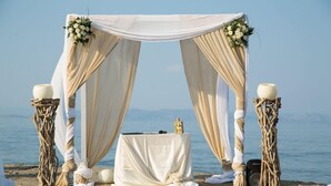 A beach wedding setup with a white canopy, a table, and decorative elements. - Agistri Apartments (Agistri)