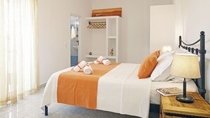 A hotel room with a bed, a nightstand, a lamp, and a window with curtains. - Agistri Apartments (Agistri)